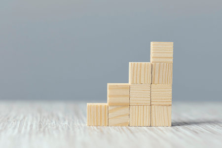 wood block stacking as step stair on wooden table. Business concept for growth success process.
