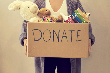 Donation box with children toys. woman collects toys for charity.