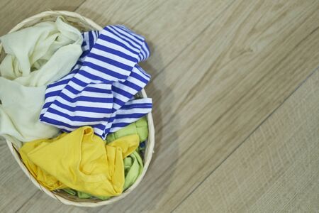 Top view Clothes in a laundry basket on Wood floorの写真素材