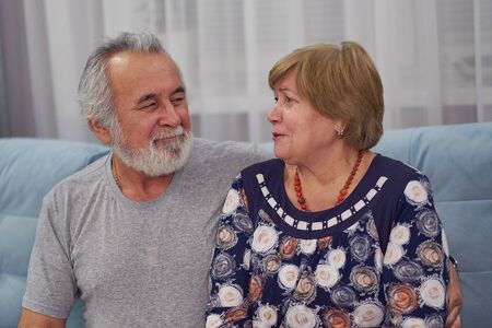 Close up head shot happy senora woman talking with senior husband. Smiling mature family couple having fun, chatting, together at home.の写真素材