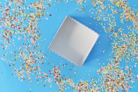 Open empty gift box with blue ribbon, confetti and ballsの写真素材
