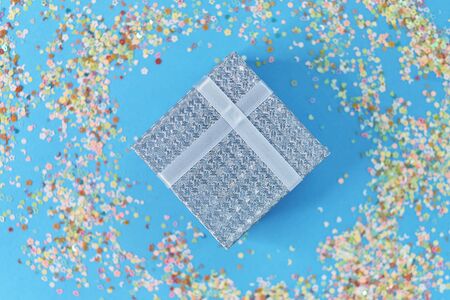 gift box with blue ribbon, confetti and ballsの写真素材