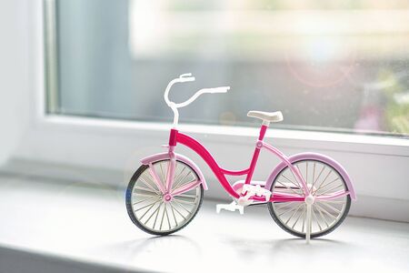 bicycle childrens plastic toy on the windowsill at home. the concept of summer walksの写真素材
