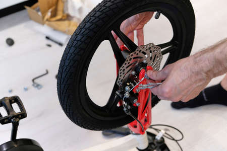 man assembling new bicycle to learn to ride. disc wheels. inflatable tiresの写真素材