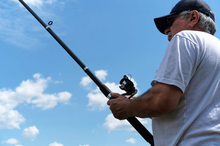 Fishing in river.A fisherman with a fishing rod on the river bank. Man fisherman catches a...