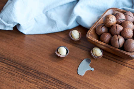 Macadamia nuts on a wooden table and linen towelの写真素材