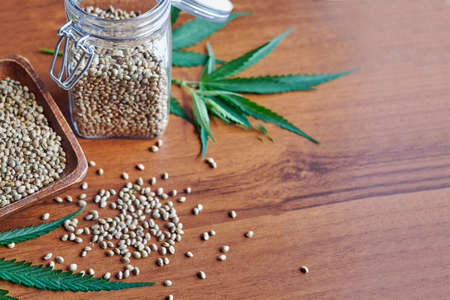 seeds hemp on the table, oil in a glass jar, cannabis leaves isolated on white backgroundの写真素材