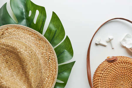 Summer outfit. Brown cross bag, headphones, straw hat. Flat lay, top view. Female, summer street style. Womens frame of accessories.の写真素材