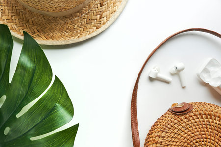 Summer outfit. Brown cross bag, headphones, straw hat. Flat lay, top view. Female, summer street style. Womens frame of accessories.の写真素材