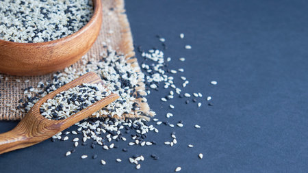 Organic natural sesame seeds wooden spoon. toasted sesame seeds. Raw, whole, unprocessed. Natural...