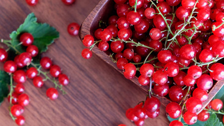 wet red currant on brown wooden table.