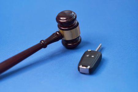 Driver license revocation concept next to the judge hammer. Traffic violation concept by car next to...