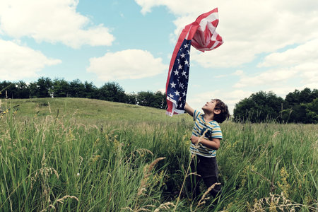 Patriotic holiday.Young boy with American flag.USA celebrate 4th of July.