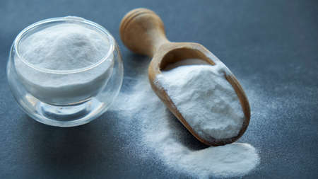 Glass bowl of baking soda. Spoonful of bicarbonate.の写真素材