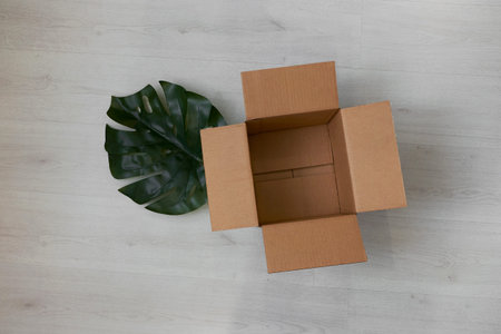 Flat lay of empty open cardboard box on wooden surface
