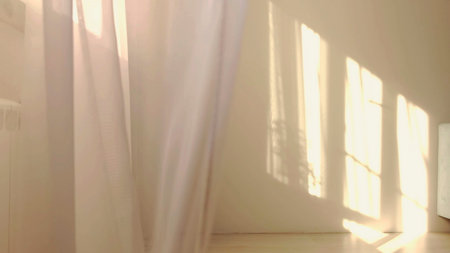 wind blows through the open window in the room. Waving white tulle near the window. Morning sun...