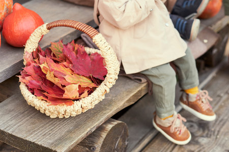 two sitting in autumn clothes on the steps next to a pumpkin