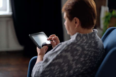Senior Indian Woman Using Digital Tablet At Home.の写真素材