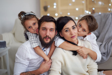Closeup portrait of cute cheerful family lying down at home, love conceptの写真素材