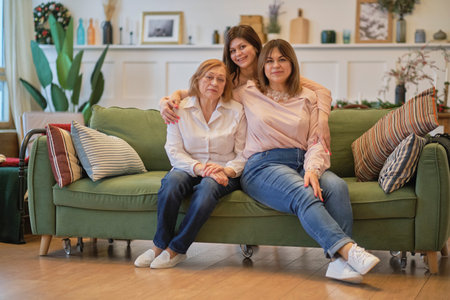 middle aged mother grown up adult daughter and grandmother, women from different generations together at home, love warm relationships and affectionate conceptの写真素材