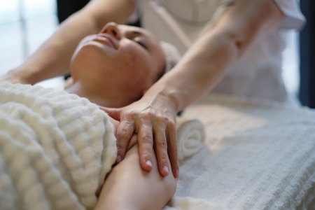 Beautiful girl has a facial massage in a beauty clinic. skin care, spa concept, treatment. Face massage. Facial skincare. Hands of masseur. Woman at beauty spa salon.の写真素材
