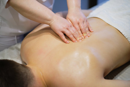 Close-up of man enjoying in relaxing back massage . Man relaxing on massage table receiving massageの写真素材