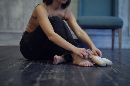 modern dancer in jeans puts on pointe shoes, classical and modern style concept in art.の写真素材