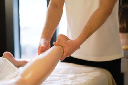 Relaxing massage on the foot in spa salon indoors.の写真素材