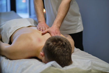 Close-up of man enjoying in relaxing back massage . Man relaxing on massage table receiving massage