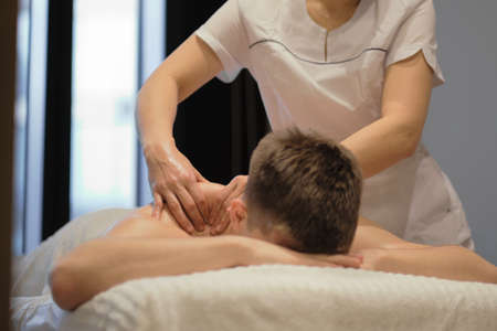 Close-up of man enjoying in relaxing shoulders massage . Man relaxing on massage table receiving massageの写真素材
