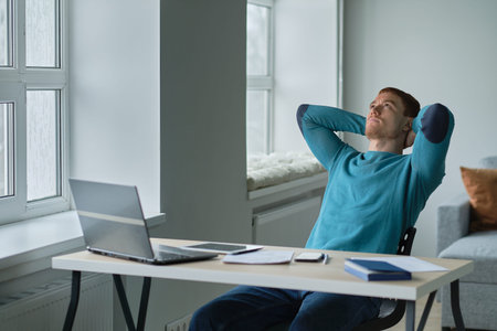 Satisfied with work done. Man working from home happily surprised looking at a laptop with his hands...