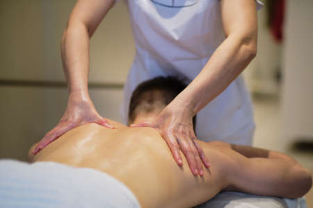 Close-up of man enjoying in relaxing shoulders massage . Man relaxing on massage table receiving massageの写真素材