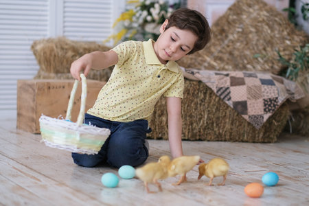 Child boy wearing bunny ears. portrait of a child sitting on the floor and holding a basket of goodies. Having fun on Easter egg hunt.の写真素材