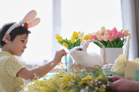 Happy easter. Child boy in bunny ears and hare sits in a wicker basket for spring holiday...