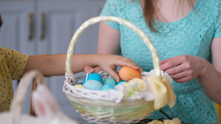 concept preparation for easter party, lifestyle. young woman decorates Easter basket in cozy kitchen...