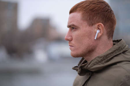 Handsome serious beauty male model closeup portrait, young guy in the city street. Cold blue tones in urban cityの写真素材