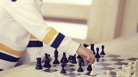 little child plays chess. child hand making right move
