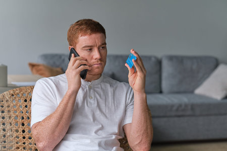 Man paying with credit card on smart phone at home. Online payment. shop on mobile. Mans holding a...
