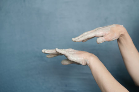 female hands clotted mud clay play cheerfully and show hands. Hands dirtyの写真素材