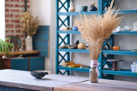 Unfinished clay pots on shelves as part of a ceramic pottery workshop. Creative studio potter. different ceramic dishware on wooden shelves.の写真素材