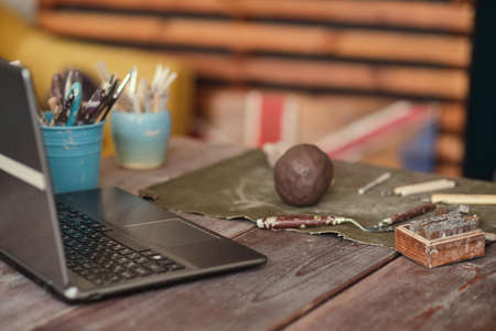 clay and tools are on the table in front of the laptop. ceramics online training concept. video tutorials for hobbies. Pottery toolsの写真素材
