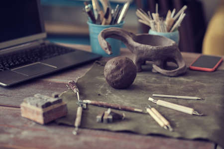 clay and tools are on the table in front of the laptop. ceramics online training concept. video tutorials for hobbies. Pottery toolsの写真素材