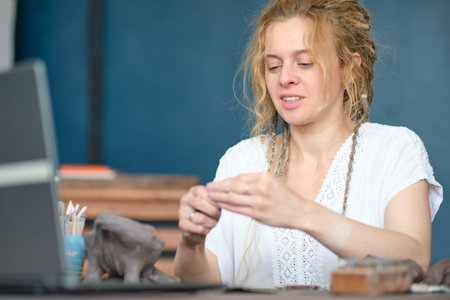 artisan pottery tutor in art studio. woman ceramist teaches an online lesson or leads a video master...