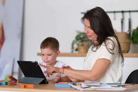 Mother with young boy using digital tablet.happy mom and baby play educational online games on the tablet.の写真素材