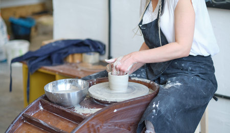 Female Potter creating a earthen jar on a Potters wheel