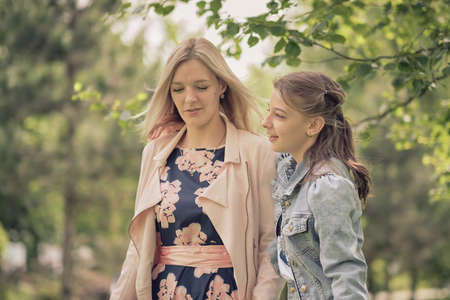 happy mother with her daughter hugging a teenager in the summer. Caring happy mother enjoy day with teenage girl child, laugh have fun. Mother giving her daughter advice.の写真素材