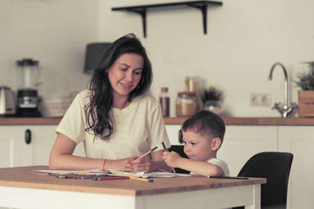 little boy learns to draw. Mom and son have fun drawing with pencils. Childrens creativity.の写真素材