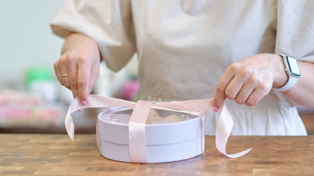 woman entrepreneur packs the order in a beautiful box, perfect service for customers.