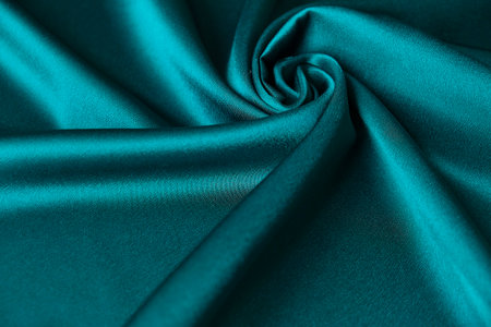 Blue silk drapery and upholstery fabric from the courtyard. Blue satin, silky fabric, wave, draperies. Beautiful textile backdrop. Close-up. Top viewの写真素材