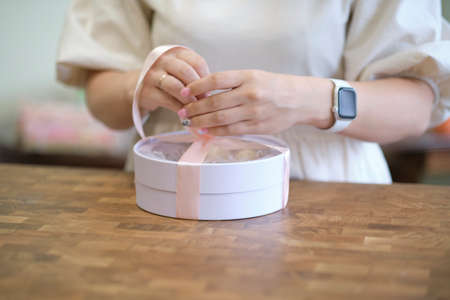 woman entrepreneur packs the order in a beautiful box, perfect service for customers.の写真素材